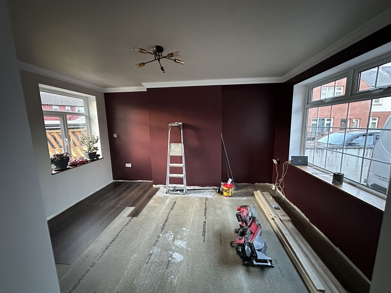 Living room mid-refurbishment with feature walls and new flooring being laid