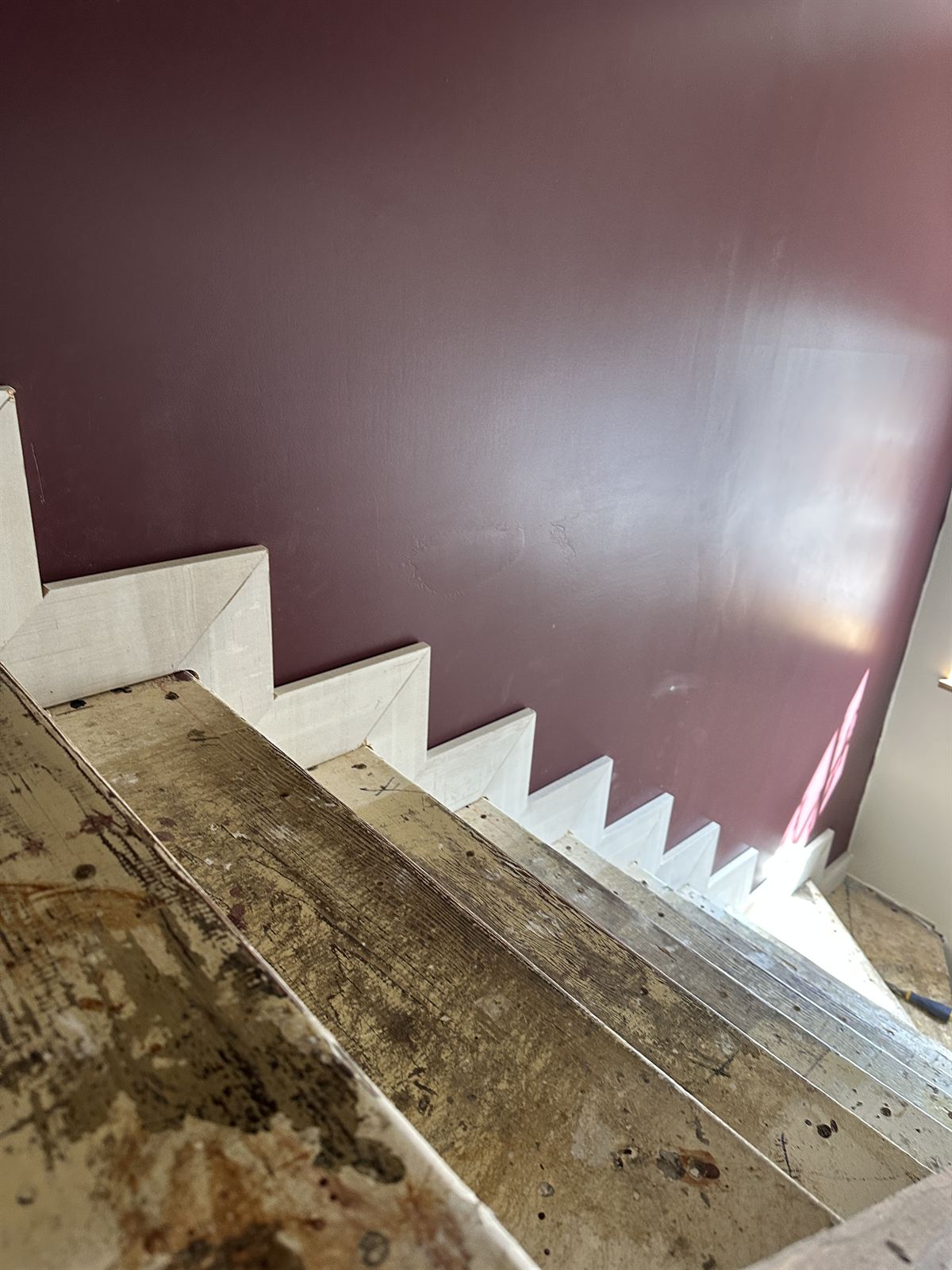Burgundy resin floor beside a restored timber staircase
