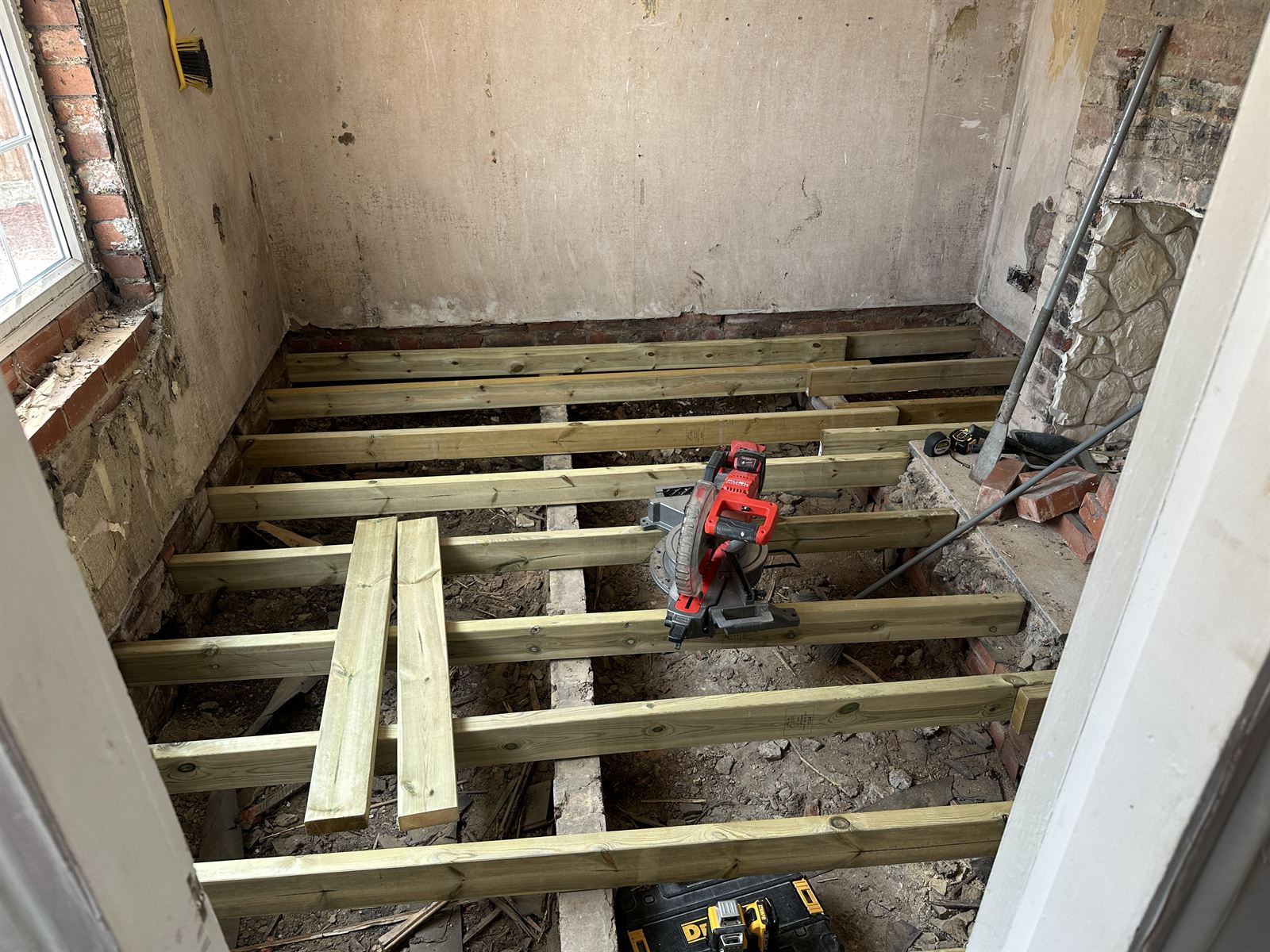 New treated timber floor joists installed in a stripped room